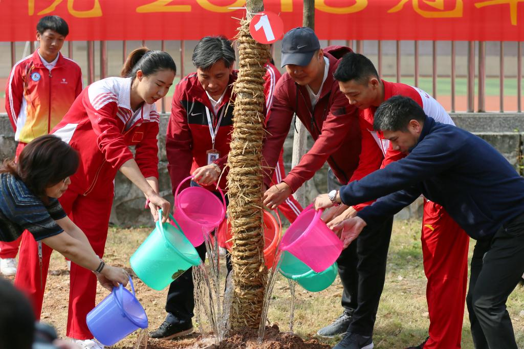 学院党委书记孔茂胜、世界冠军钟佩莹、带训教练宋健和教职工代表、运动员代表一起植树